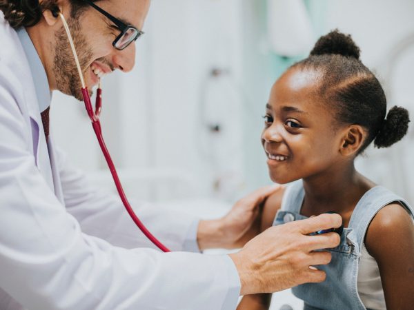 Friendly pediatrician checking a little girls heart